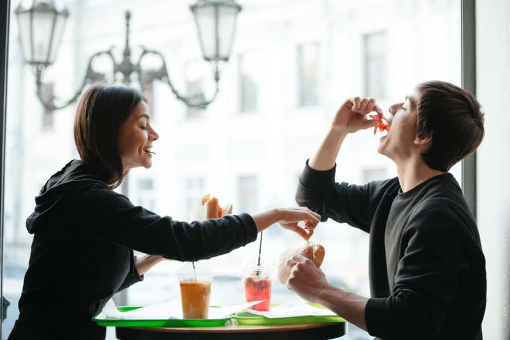 frere et soeur heureux entrain de manger un repas